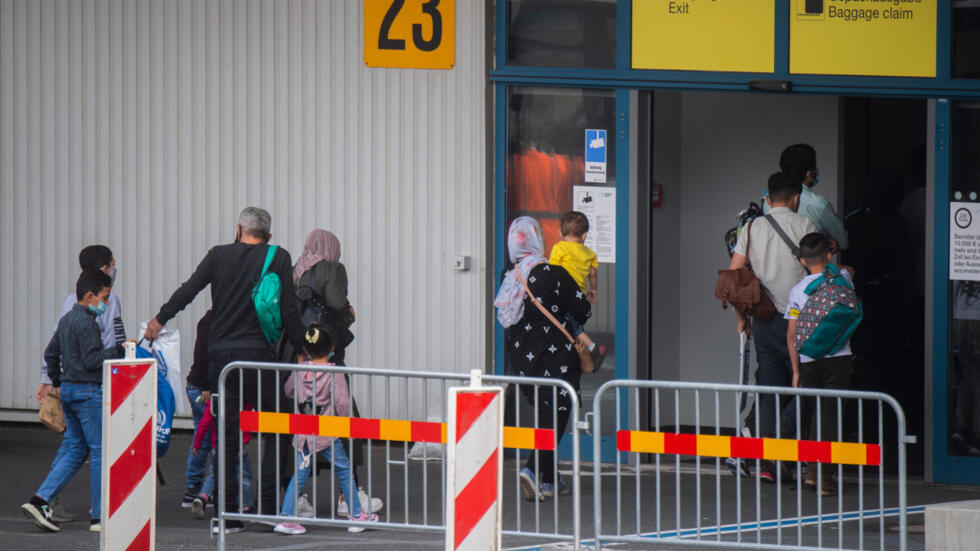 Una familia de migrantes procedentes de Moria en el Aeropuerto de Hannover, en Alemania. Foto: AFP.